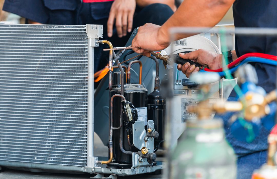 Technician repairing a commercial cooling unit during HVAC service work