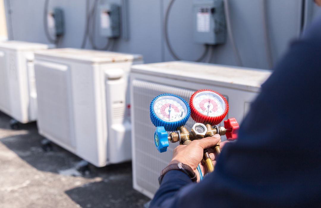 Technician checking refrigerant gauges during commercial HVAC maintenance service