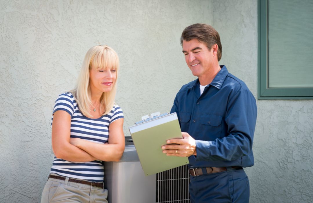Technician reviewing residential HVAC installation details with a homeowner