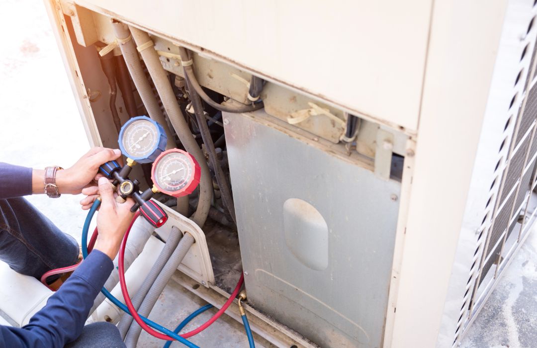Technician checking refrigerant gauges during residential HVAC installation service