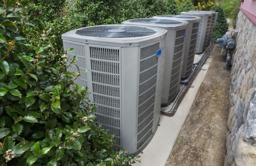 Multiple residential outdoor HVAC units installed beside a home