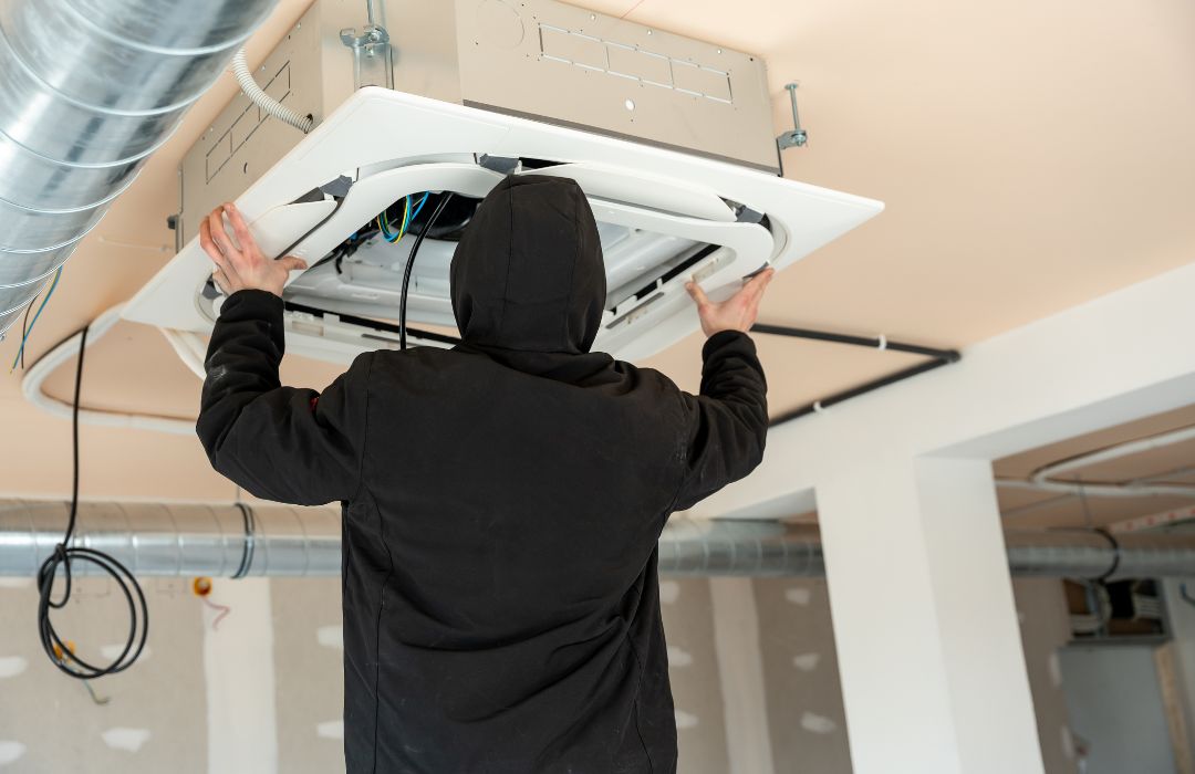 installing a ceiling-mounted commercial HVAC cassette unit indoors