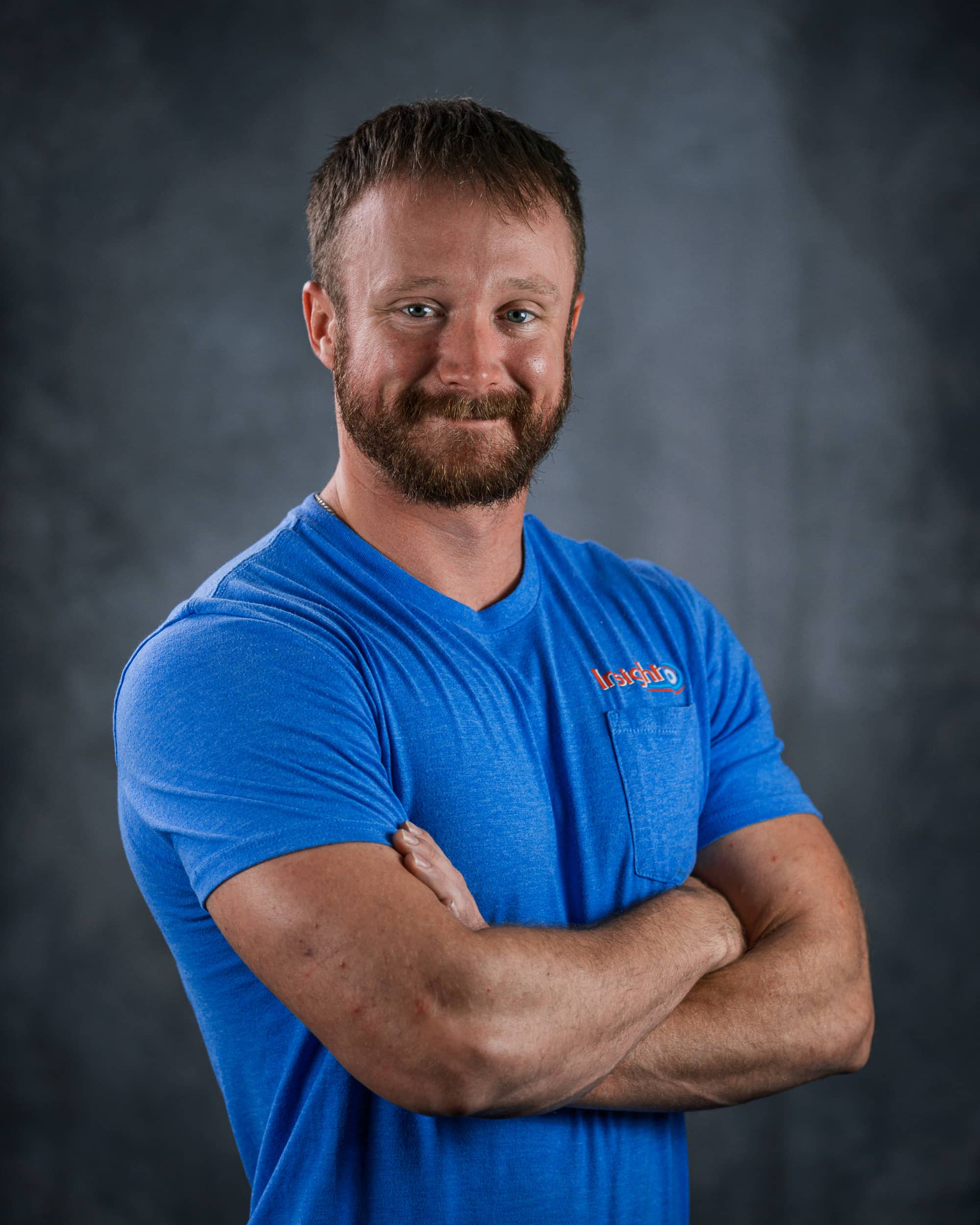 Insight Mechanical Services team member portrait with arms crossed in blue company shirt